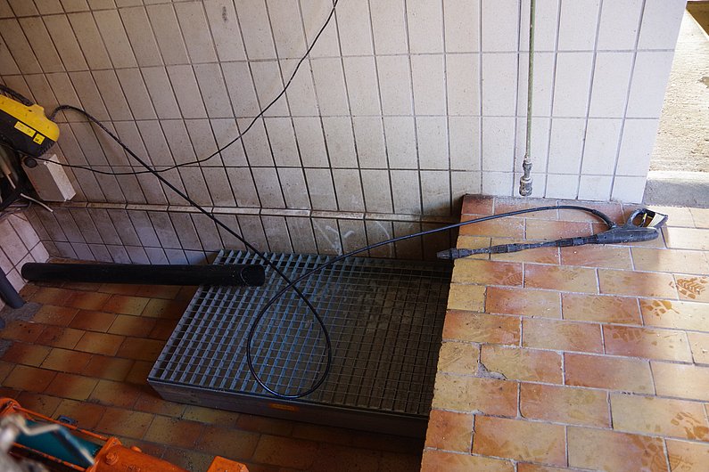 Ein Hochdruckreiniger liegt in einem Stall. Klick führt zu Großansicht in neuem Fenster.