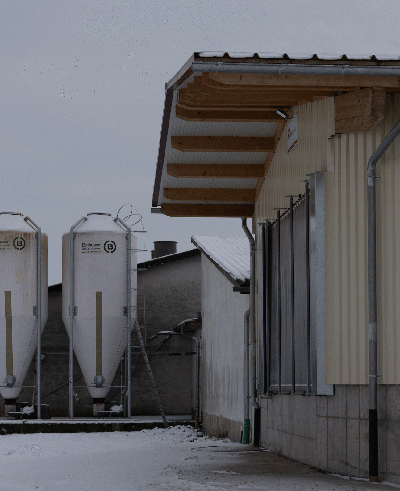 Der Blick richtet sich auf zwei Futtersilos, die am Ende eines Hofes stehen. Klick führt zu Großansicht im neuen Fenster. 