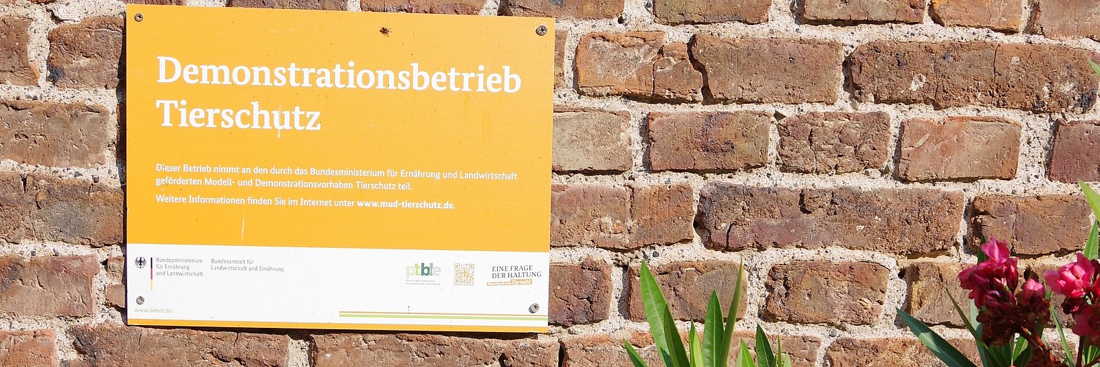 Hofschild eines Demonstrationsbetriebes auf Hauswand