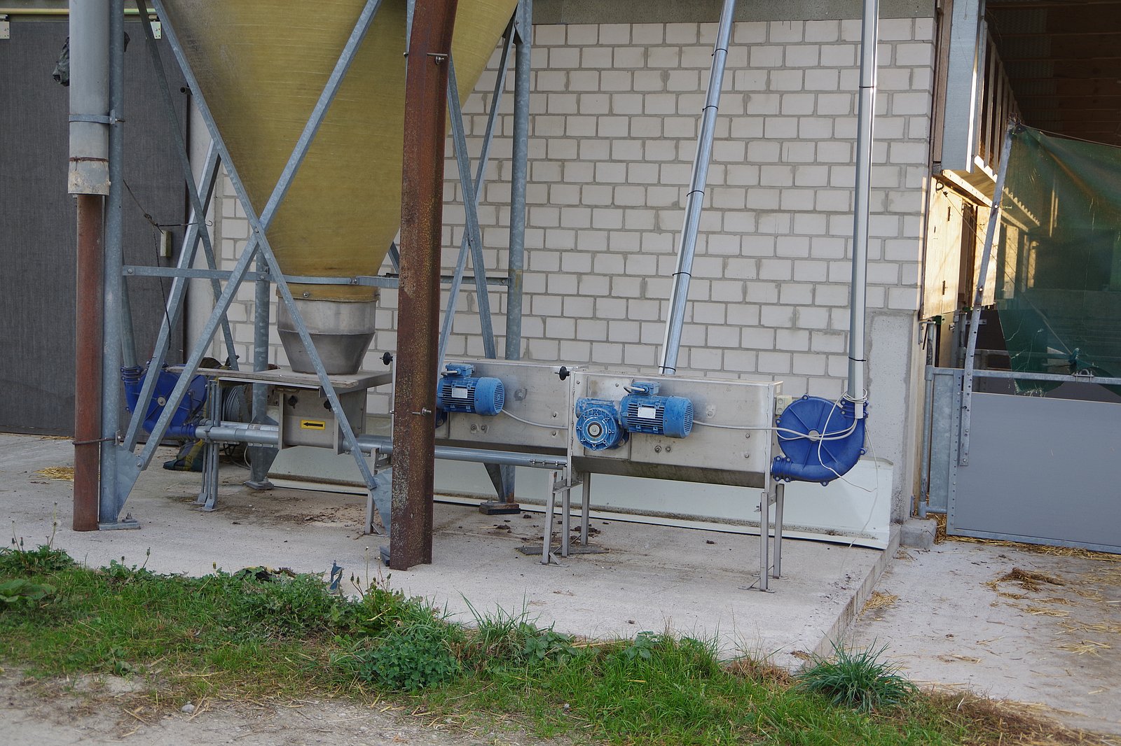 Das Bild zeigt einen Futtersilo mitsamt Förderanlage. Klick führt zu Großansicht in neuem Fenster.